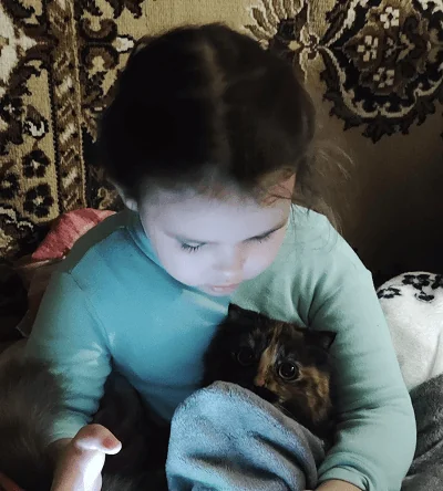 My daughter in the basement, holding the family's cat
