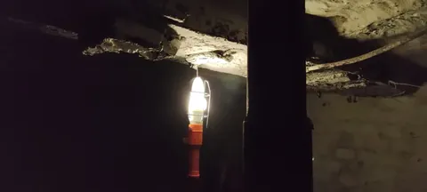 A single bulb hanging from the basement ceiling, the only light in the dark.